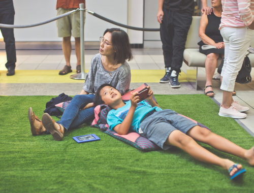 Woman and a boy on the fake grass looking up the LED Constellation