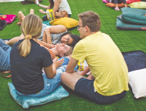 Group of people sitting laying under LED Constellation