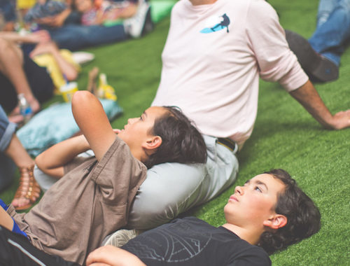 People lying on the fake grass looking up