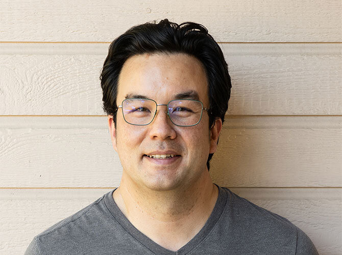 Man posing in front of wall.